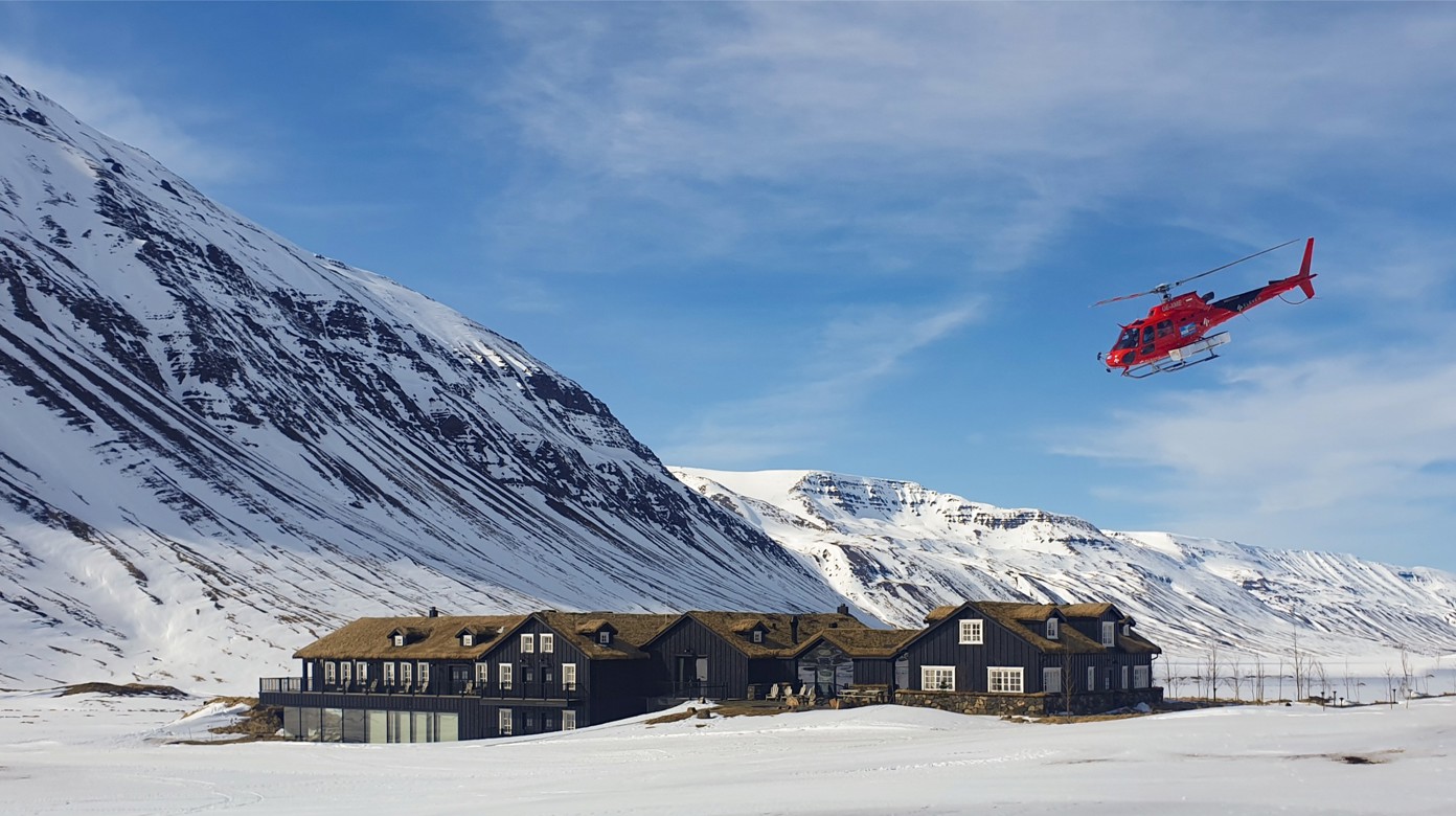 A red helicopter flying over Deplar Farm.